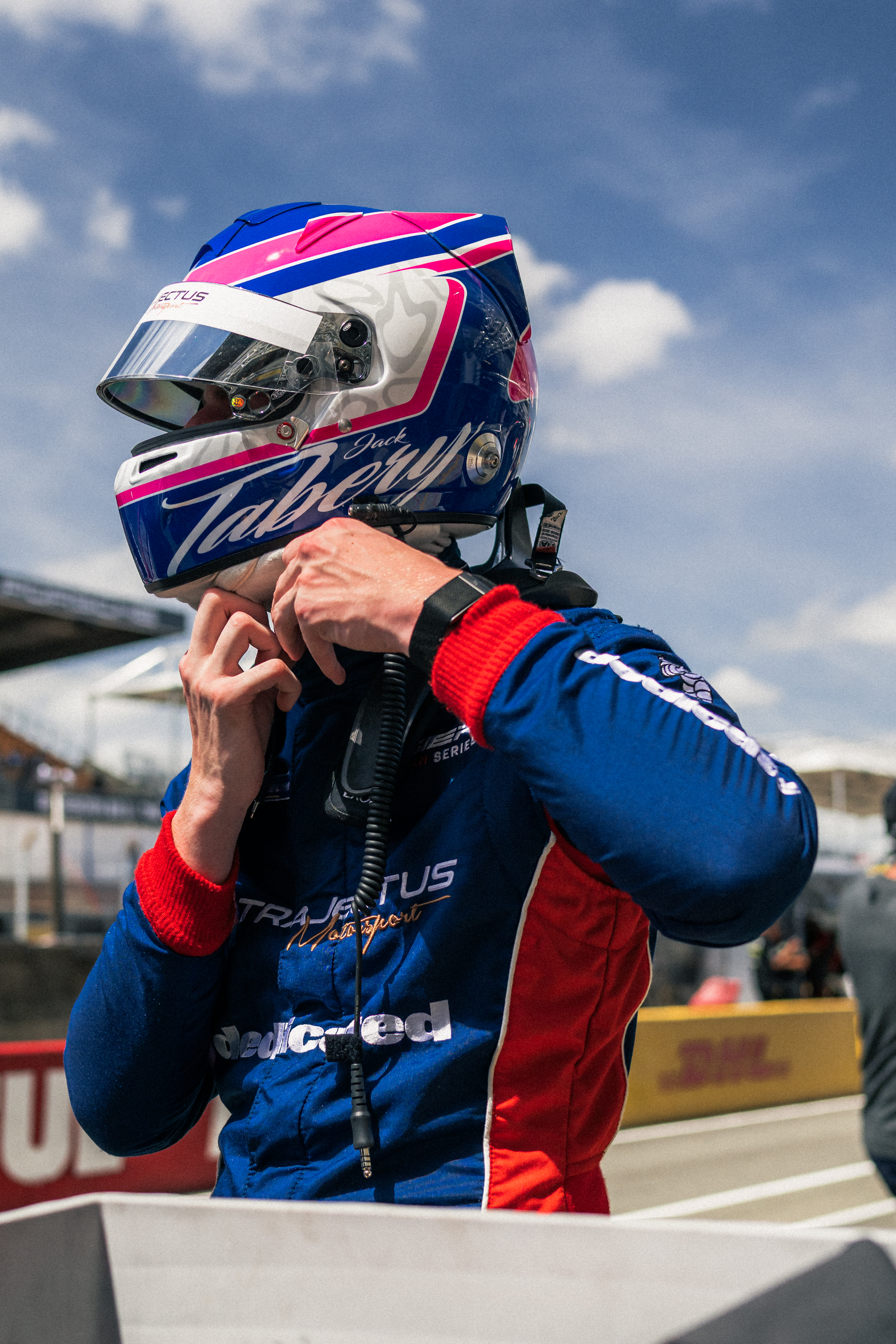 Portrait de Jack Tabery en tenue de pilote, dans le garage de l'équipe